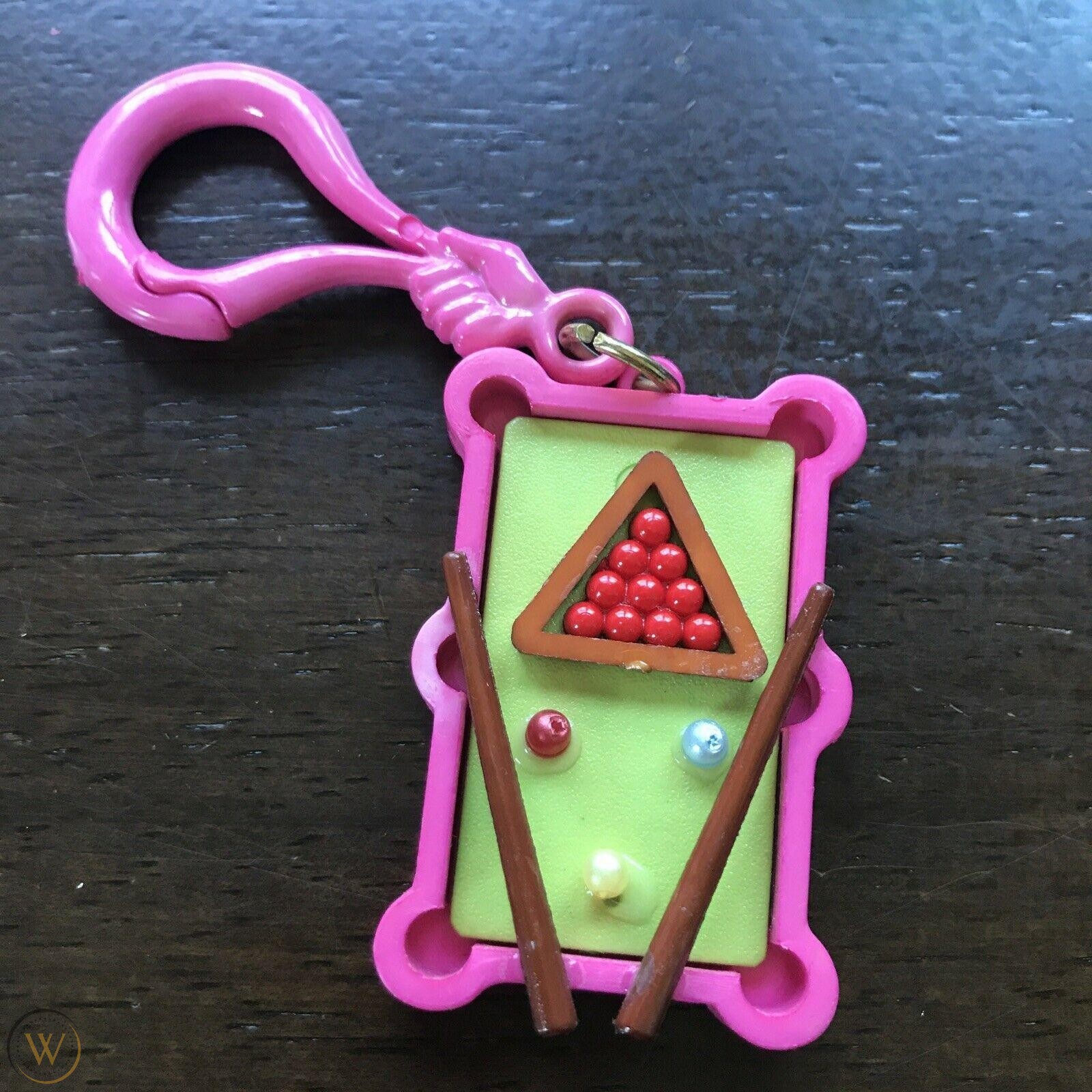 a plastic bell charm resembling a miniature pool table