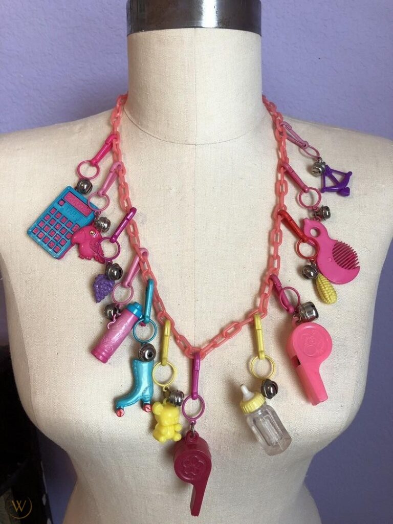 a pink chainlink necklace adorned with twelve colorful bell charms