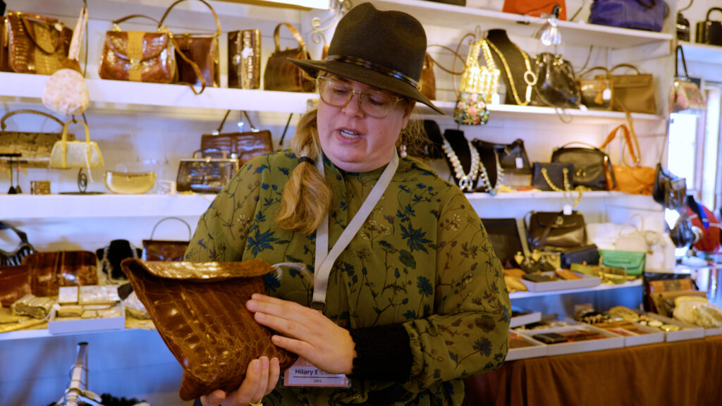 Hilary eisman shows off an alligator purse