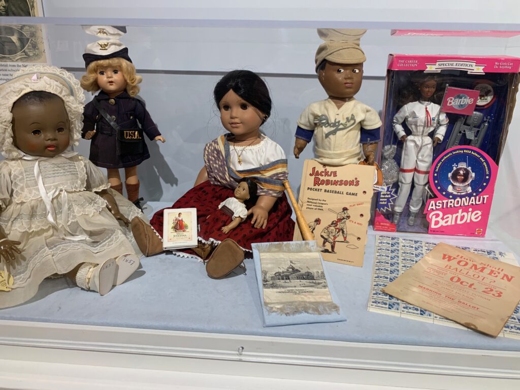 selection of dolls display Astronaut Barbie American Girl